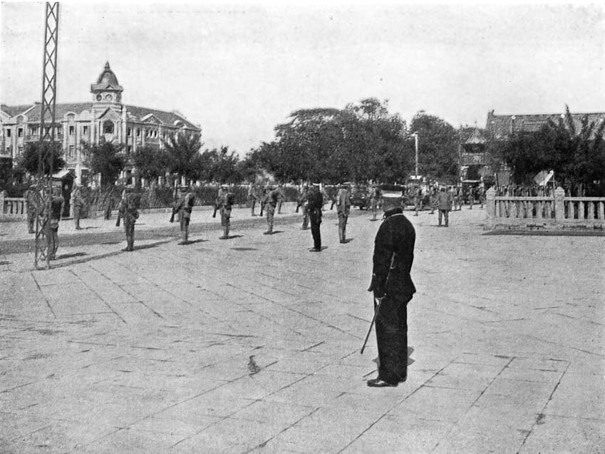 Modern Peking: The Palace Entrance lined with Troops. Note the New-type Chinese Policeman in foreground.