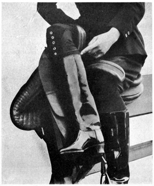 Fig. 80.—Hooked back leg, the direction of the pressure of which is shown by the fore finger of the left hand. Woman seated in side-saddle on stand